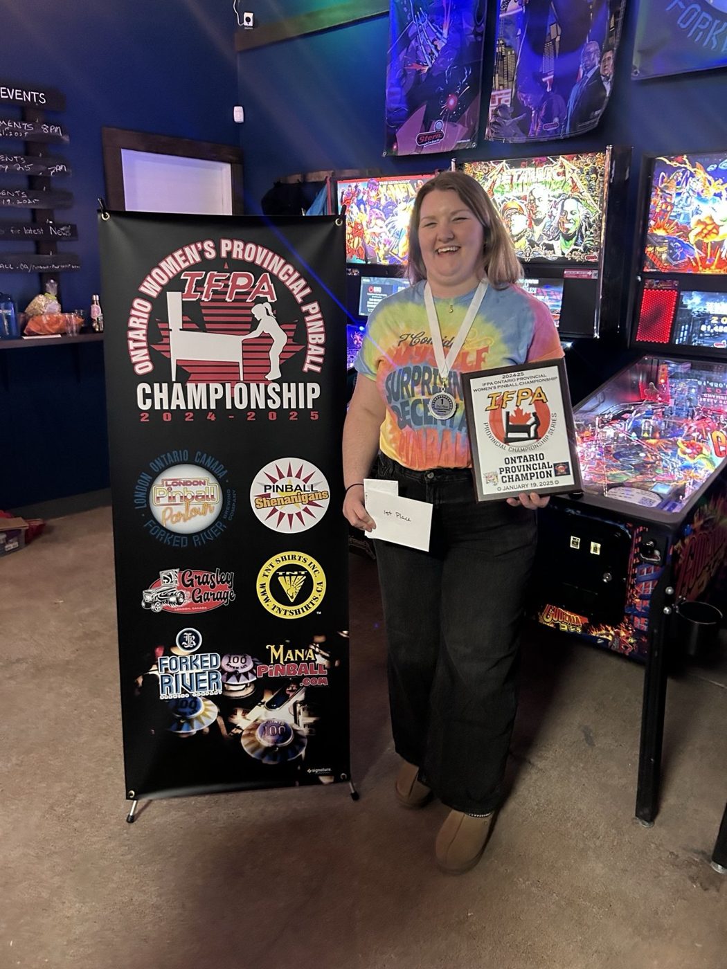 Haley Natale, the 2024-25 Ontario women's provincial champion, holding her plaque beside the championship banner